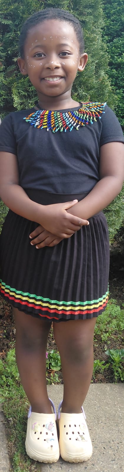 A smiling JENS learner celebrating Heritage Day in black clothing with colourful traditional beadwork
