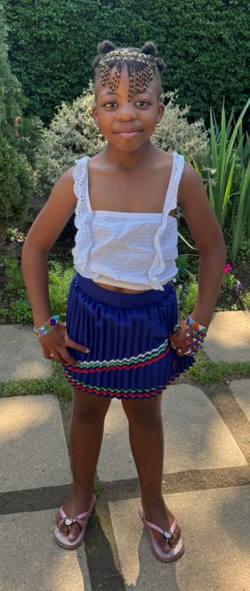 A JENS learner celebrating Heritage Day in a blue skirt with colourful traditional beadwork