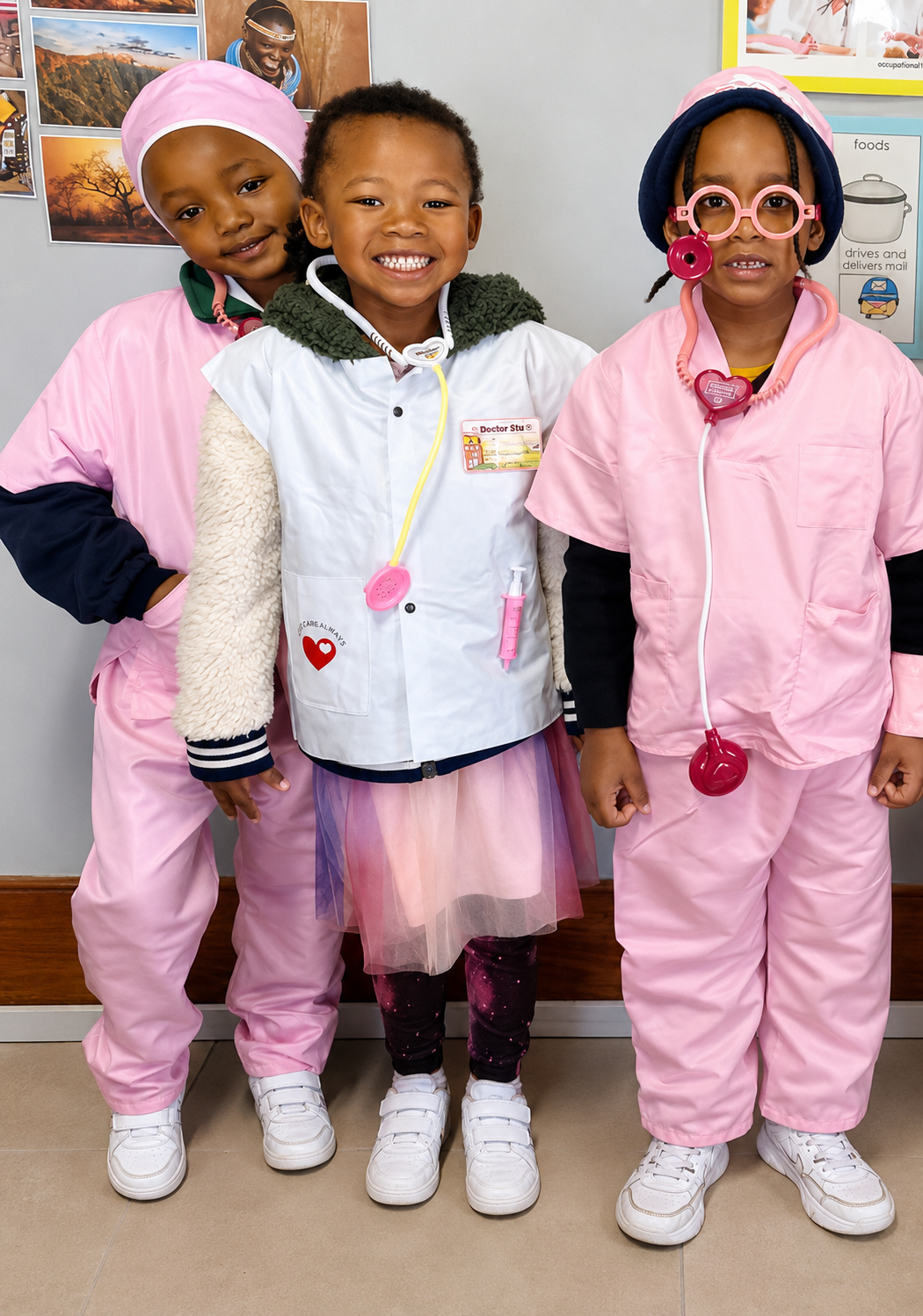 Three JENS learners dressed as doctors and nurses in pink scrubs on a career dress-up day