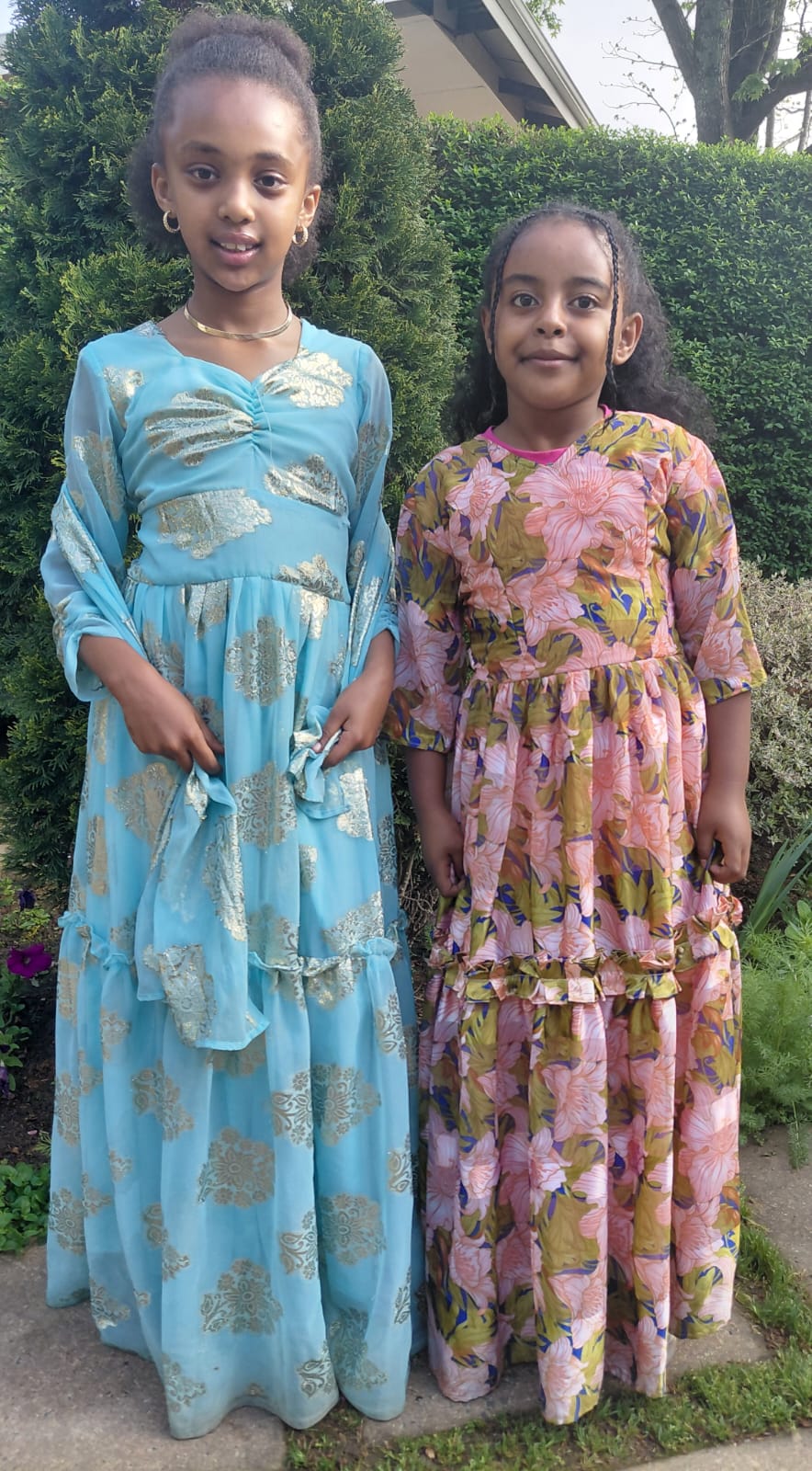 Two JENS learners celebrating Heritage Day together in colourful blue and floral dresses