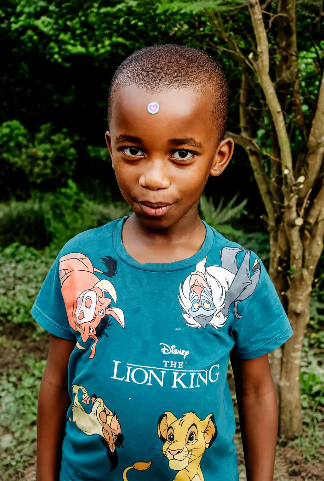 A JENS learner in a Lion King t-shirt smiling outside on a civvies day