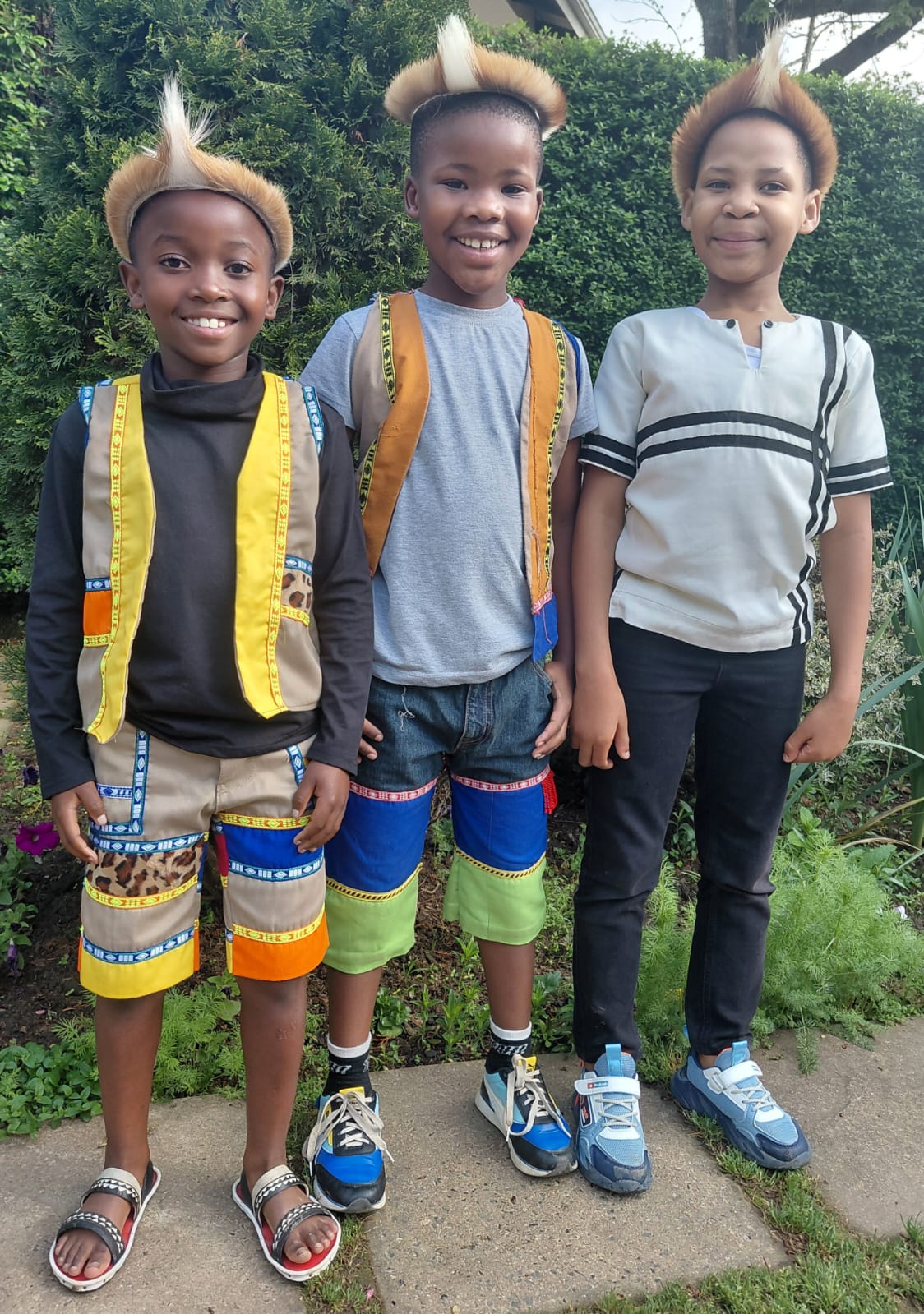 Three smiling JENS learners celebrating Heritage Day together in colourful traditional clothing