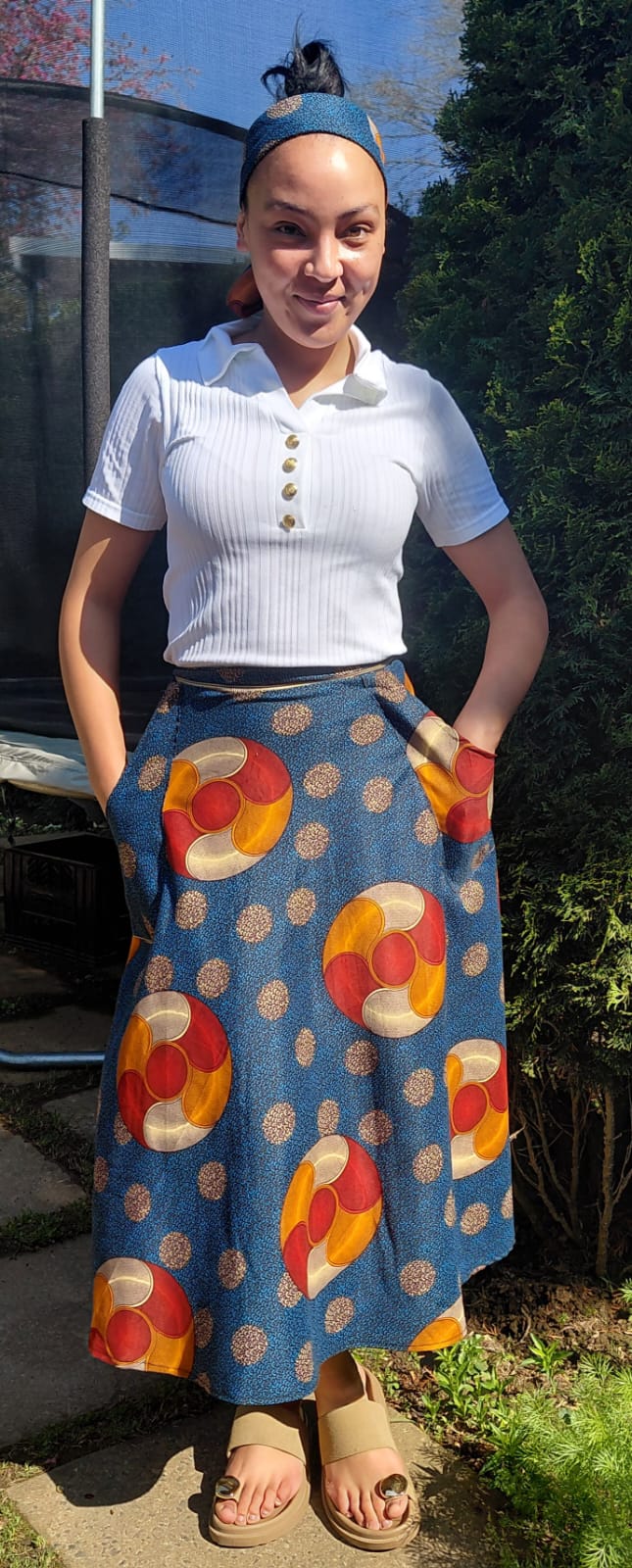 A member of the JENS family celebrating Heritage Day in a patterned blue traditional skirt and matching headband